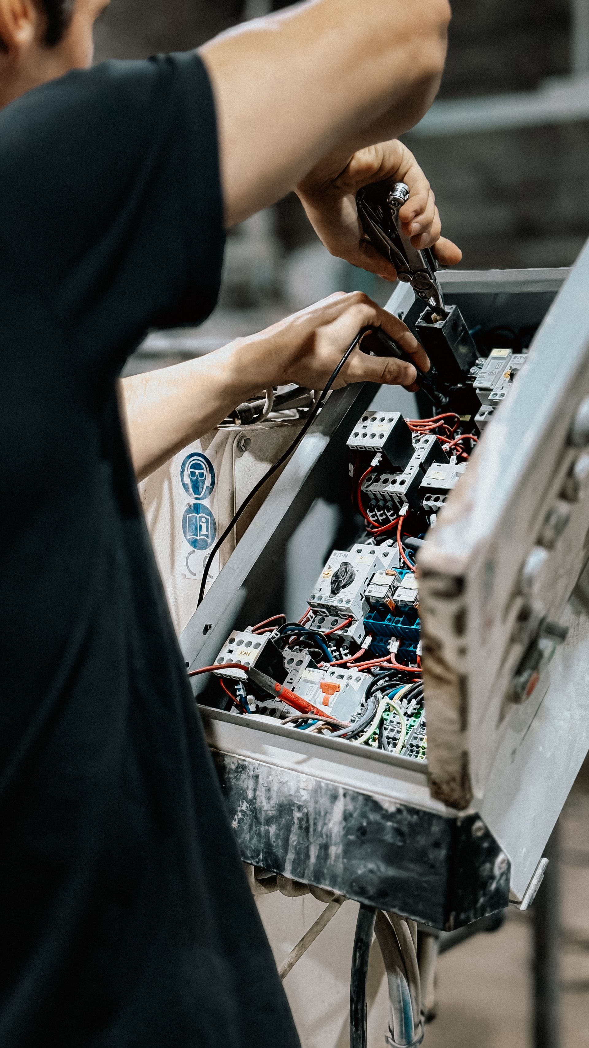 Technician carrying out maintenance inside an electrical control panel